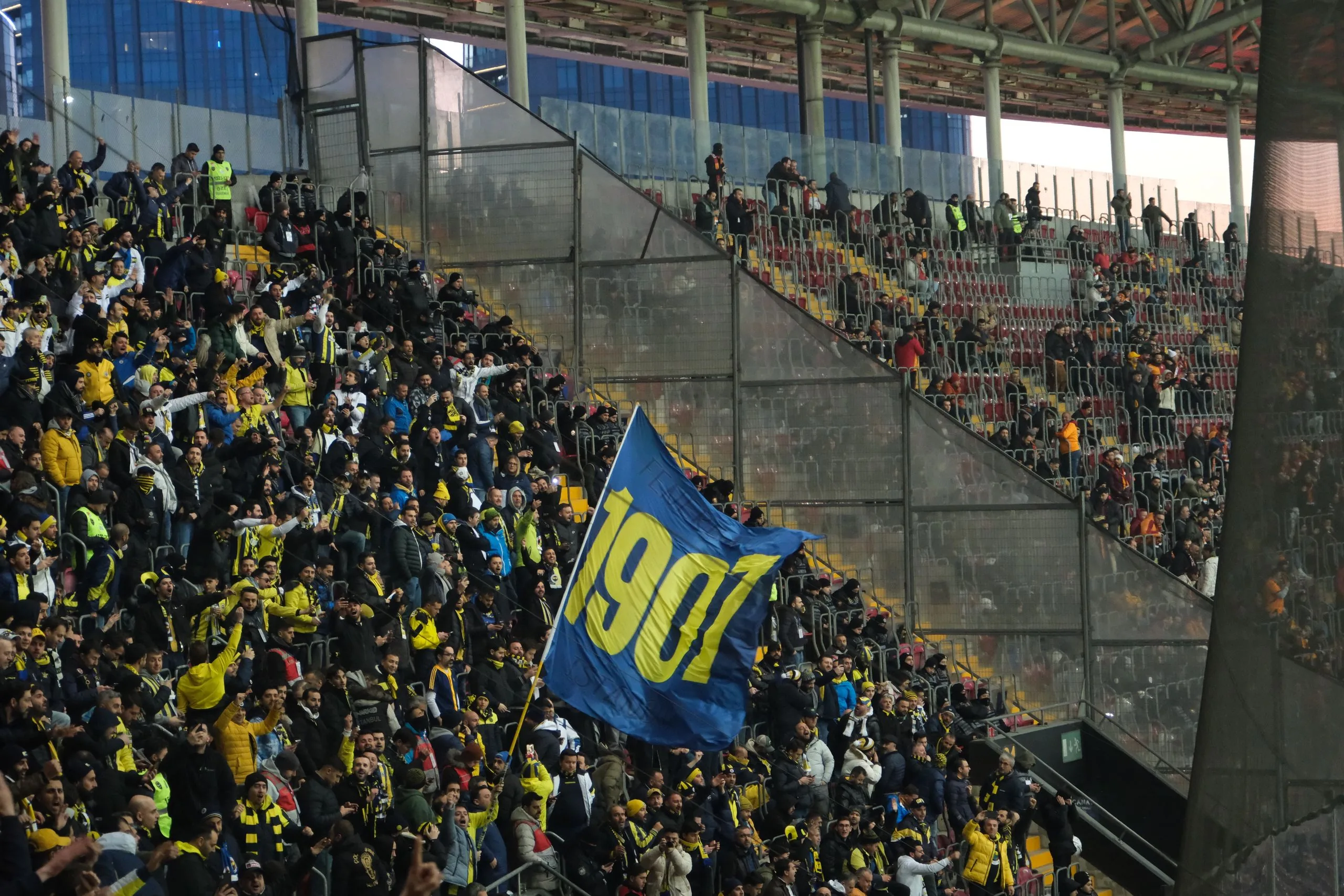 Packed stand with flags and supporters